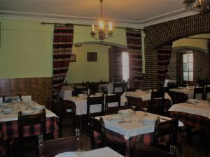 a restaurant with white tables and chairs and a chandelier at Hostal Restaurante Ceres in Magaz De Pisuerga +16 photos