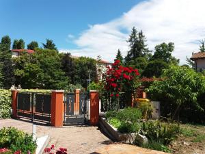 um portão num jardim com rosas vermelhas em B&B Casa di Chiara em San Michele al Tagliamento