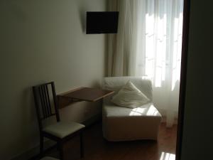 a living room with a chair and a couch and a table at Areia Da Foz in Figueira da Foz