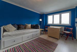 チェスキー・クルムロフにあるVilla Cihelna apartmentsの青い壁のベッドルーム1室、ベッド1台、デスクが備わります。