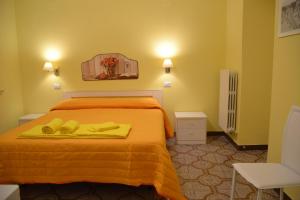 a bedroom with a bed with yellow sheets and shoes on it at Alloggio Turistico La Balocca in Montefiascone