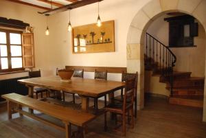 a dining room with a table and chairs and a staircase at La Casa de Alberto in Ribas de Tereso