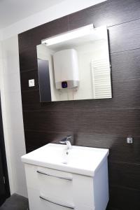 een badkamer met een witte wastafel en een spiegel bij Deluxe Apartment Nika in Kaštela