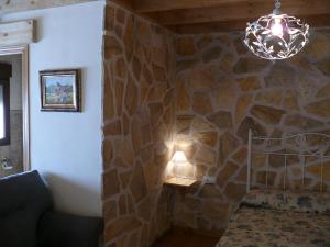 um quarto com uma parede de pedra com um candeeiro e um sofá em Abadía del Marqués de Avila em Vega de Santa María