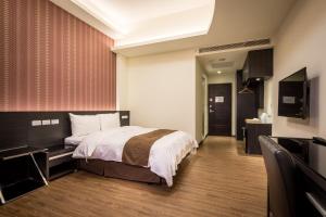 Habitación de hotel con cama y TV de pantalla plana. en Midu Business Hotel en Xiluo