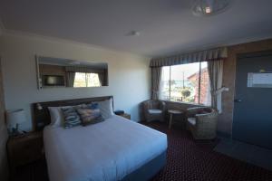 מיטה או מיטות בחדר ב-Anchor Bay Motel