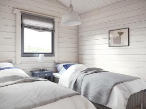 two beds in a room with a window at Domki Aleja Róż in Międzyzdroje