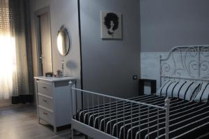 ナポリにあるMeridional Stationのベッドルーム1室(ベッド1台、ドレッサー、鏡付)