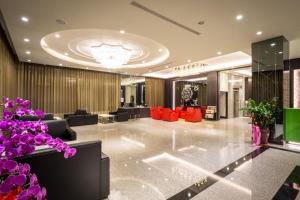 una hall con divani e fiori viola in un edificio di Midu Business Hotel a Xiluo