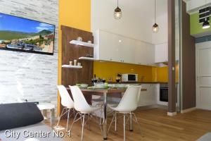 een keuken met een eettafel en witte stoelen bij Apartments City Center in Zagreb