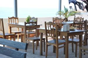 a dining room with wooden tables and chairs at Akhmed Guest House in Kvariati