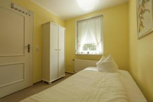 ティメンドルファー・シュトラントにあるDas Sonnenblumenhausのベッドルーム(白いベッド1台、窓付)