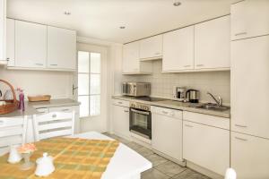 a kitchen with white cabinets and a table at Das Sonnenblumenhaus in Timmendorfer Strand