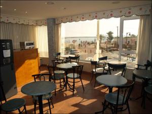 a restaurant with tables and chairs and a view of the beach at Hotel Los Molinos in Lo Pagán