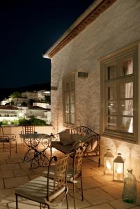 a table and chairs on a patio at night at Cotommatae Hydra 1810 in Hydra
