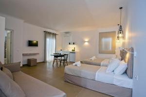 ミコノス・シティにあるNida Mykonosのベッド2台とソファが備わるホテルルームです。