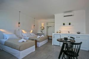a living room with two beds and a table at Nida Mykonos in Mikonos