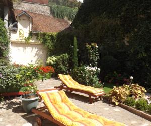 2 Stühle auf einer Terrasse im Garten in der Unterkunft La Chuchotiere in Sainte-Maure-de-Touraine