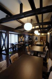 Großes Zimmer mit Tischen, Stühlen und Fenstern in der Unterkunft Nakadaya in Takayama