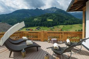 2 sillas en una terraza con vistas a la montaña en Der Paternwirt en Maria Luggau