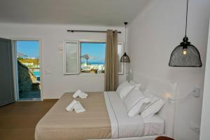 a bedroom with a bed and a view of the ocean at Nida Mykonos in Mikonos +41 photos