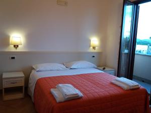a bedroom with a bed with two towels on it at Il Piccolo Nido in Borgo Montenero