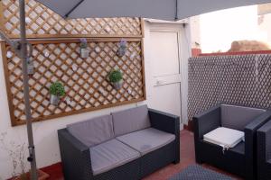a patio with two chairs and a table and a door at Penthouse duplex in center in Seville