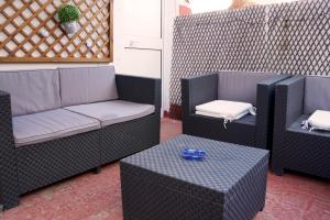 a patio with two chairs and a couch and a table at Penthouse duplex in center in Seville