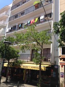 an apartment building with a yellow awning and balconies at Pensión Juan Ramón in Lloret de Mar