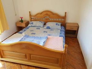 um quarto com uma cama de madeira e 2 mesas de cabeceira em Guesthouse Berlin em Bar