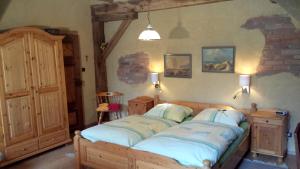 ein Schlafzimmer mit einem Bett mit blauen Kissen darauf in der Unterkunft Landhotel Sonnenhof im Wendland in Clenze