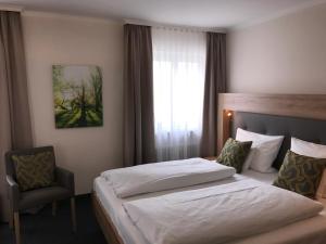 een hotelkamer met 2 bedden en een stoel bij Hotel Kronprinz in Kulmbach