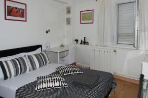 a bedroom with a bed with black and white pillows at Villa Cemaste in Montpellier