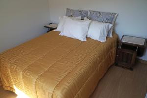 アルヴァレンガにあるQuintinha de Donimのベッドルーム1室(大型ベッド1台、黄色のベッドカバー付)