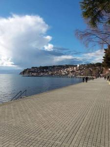 people walking on a sidewalk next to a body of water at Nova Apartments in Ohrid
