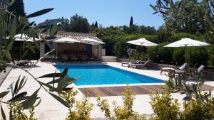 una piscina con sombrillas y una casa en Aux charmes de grasse en Grasse