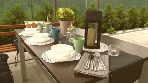 a table with plates and utensils on a patio at Willa Piasutno z klimatyzacją in Świętajno