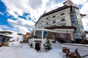 un gran edificio en la nieve frente a una pista de esquí en Hotel Onix, en Ranca