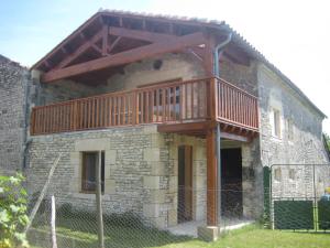 a house with a deck on the side of it at Chambre d'hôte Au col de Cygne in Blanzac-lès-Matha