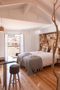 a bedroom with a large bed and a table at Bairro Alto Studio Apartments - by LU Holidays in Lisbon