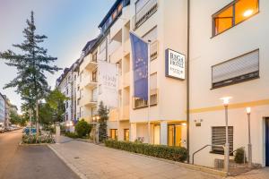 a white building with a sign on the side of it at Hotel Rega Stuttgart in Stuttgart