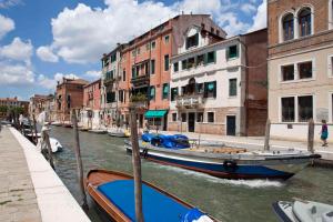 a boat is docked in a canal next to buildings at DI.GIANFRANCO PIANO NOBILE in Venice