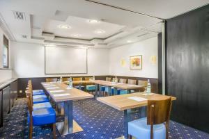 a dining room with wooden tables and blue chairs at Hotel Rega Stuttgart in Stuttgart