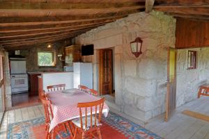 a kitchen and dining room with a table and chairs at Quinta do Galgo in Amares