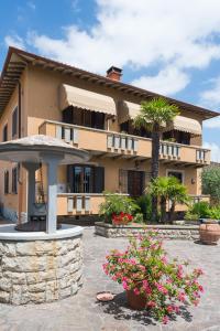 un grand bâtiment avec des palmiers et des fleurs dans une cour dans l'établissement B&B San Russorio, à Pise