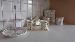 a kitchen counter with plates and cups and a sink at Gartler's Ferienhaus in Weitersfeld an der Mur