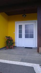 a white door on a yellow wall with a plant at Gartler's Ferienhaus in Weitersfeld an der Mur