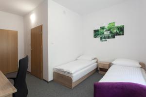 a bedroom with two beds and a desk and a table at Dom Studenta Nr 1 ANS w Koninie in Konin