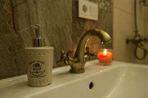 un lavabo con una botella de jabón y una vela en Provence Home, en Vilna 77 fotos más