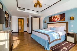 sypialnia z dużym łóżkiem z niebieskimi ścianami w obiekcie Epoque Hotel - Relais & Chateaux w Bukareszcie